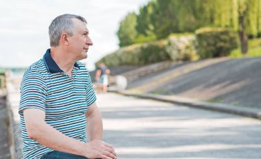 Keyfi yerinde yaşlı Avrupalı bir adam, şehir merkezinde açık hava portresi. 50-60 yıl sonra yaşam konsepti