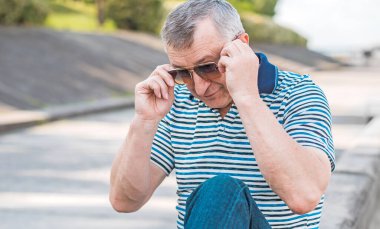 Keyfi yerinde yaşlı Avrupalı bir adam, şehir merkezinde açık hava portresi. 50-60 yıl sonra yaşam konsepti