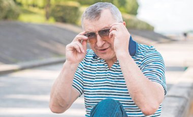 Keyfi yerinde yaşlı Avrupalı bir adam, şehir merkezinde açık hava portresi. 50-60 yıl sonra yaşam konsepti