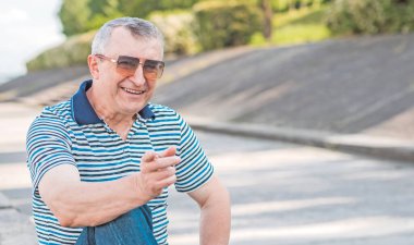 Keyfi yerinde yaşlı Avrupalı bir adam, şehir merkezinde açık hava portresi. 50-60 yıl sonra yaşam konsepti