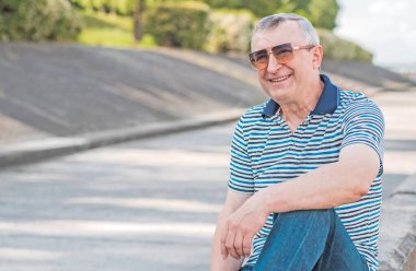 Keyfi yerinde yaşlı Avrupalı bir adam, şehir merkezinde açık hava portresi. 50-60 yıl sonra yaşam konsepti
