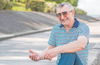 Keyfi yerinde yaşlı Avrupalı bir adam, şehir merkezinde açık hava portresi. 50-60 yıl sonra yaşam konsepti