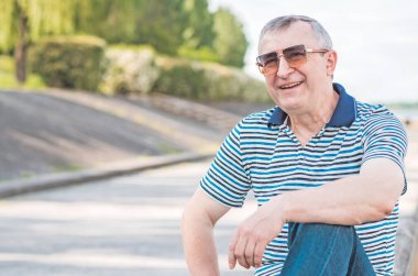 Keyfi yerinde yaşlı Avrupalı bir adam, şehir merkezinde açık hava portresi. 50-60 yıl sonra yaşam konsepti