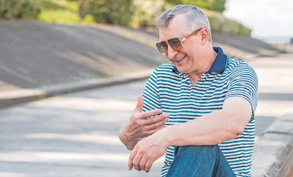 Keyfi yerinde yaşlı Avrupalı bir adam, şehir merkezinde açık hava portresi. 50-60 yıl sonra yaşam konsepti