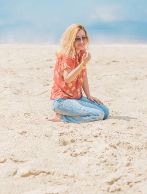 Renkli pamuklu gömlekli ve kotlu bir kadın. Moda kıyafetler, tatil konsepti. Biçim 70