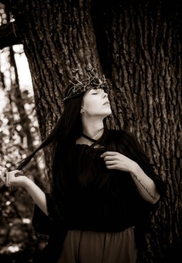 Cadılar Bayramı partisi konsepti, siyah dantel elbiseli gizemli kız. Güzel, uzun siyah saçlı, genç, kara cadı kadın. Cadılar Bayramı kutlamaları için ilham, fikirler ve basit detaylar.