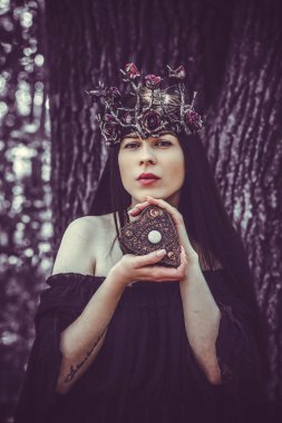 Cadılar Bayramı partisi konsepti, siyah dantel elbiseli gizemli kız. Güzel, uzun siyah saçlı, genç, kara cadı kadın. Cadılar Bayramı kutlamaları için ilham, fikirler ve basit detaylar.