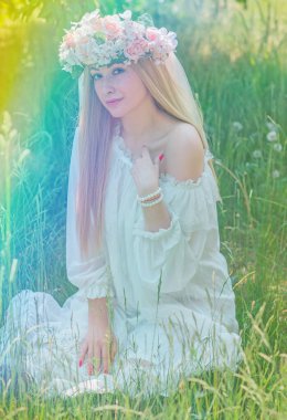 Doğadaki hassas gelin, beyaz dantelli ve çelenkli uzun sarı saçlı geleneksel Avrupalı bayan.   