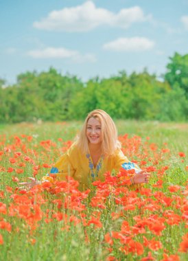 Mavi elbiseli, sarı elbiseli kız nakışlı Boho elbisesi. Haşhaş tarlasında şık sarışın kadın.