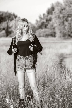 Amerikan tarzı seksi kız, süet deri boho ceket ve şort, doğada kovboy kız tarzı.