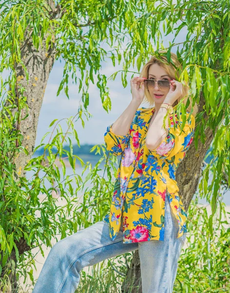 休暇のスタイル 女性のワードローブ 青いジーンズとビーチでカラフルな綿のシャツでブロンドの髪の若いヨーロッパの日焼けした女性のイラスト — ストック写真