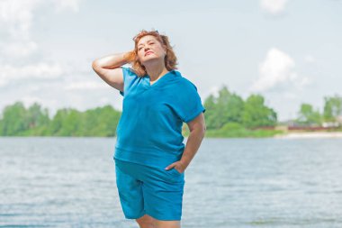 Artı mavi takım elbiseli, tatildeki boy kadın. Tatil ve hayatın tadını çıkar, olgun kadın hayatı kavramı, vücut pozitifliği.
