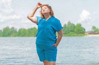 Artı mavi takım elbiseli, tatildeki boy kadın. Tatil ve hayatın tadını çıkar, olgun kadın hayatı kavramı, vücut pozitifliği.