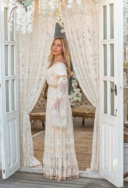 Dantelli, kayısı desenli elbisesi olan sarışın güzel bir kadın. Düğün ve akşam elbisesi konsepti