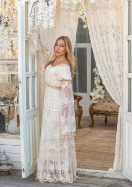 Dantelli, kayısı desenli elbisesi olan sarışın güzel bir kadın. Düğün ve akşam elbisesi konsepti