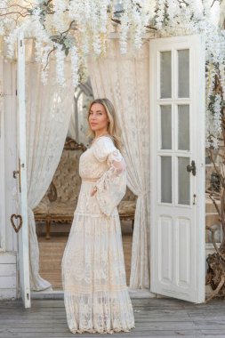 Dantelli, kayısı desenli elbisesi olan sarışın güzel bir kadın. Düğün ve akşam elbisesi konsepti