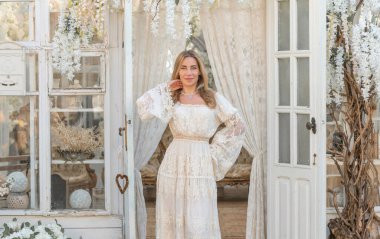 Dantelli, kayısı desenli elbisesi olan sarışın güzel bir kadın. Düğün ve akşam elbisesi konsepti