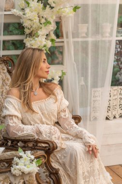 Dantelli, kayısı desenli elbisesi olan sarışın güzel bir kadın. Düğün ve akşam elbisesi konsepti