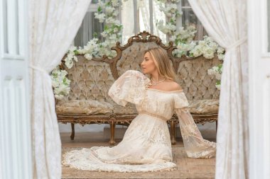 Dantelli, kayısı desenli elbisesi olan sarışın güzel bir kadın. Düğün ve akşam elbisesi konsepti