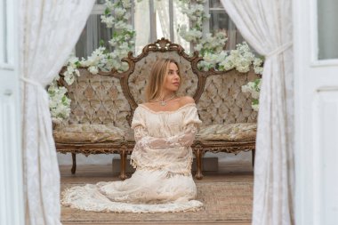 Dantelli, kayısı desenli elbisesi olan sarışın güzel bir kadın. Düğün ve akşam elbisesi konsepti