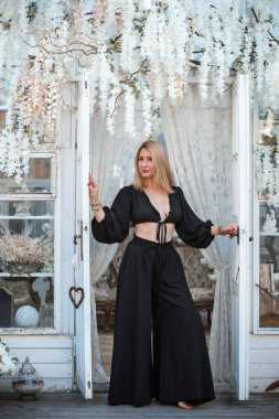 Siyah keten takım elbiseli, üst ve pantolon giyen bir kadın. Şık bir bayan giysisi.