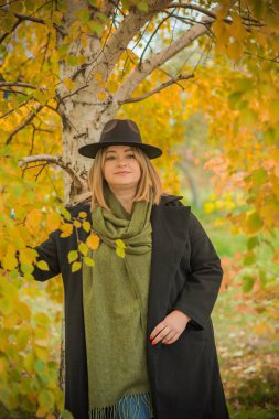 Sıcak sonbahar havasında, olgun, modaya uygun bir kadın. Orta yaşlı, güzel bir bayan. Tombul kadın yaşam tarzı