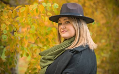 Sıcak sonbahar havasında, olgun, modaya uygun bir kadın. Orta yaşlı, güzel bir bayan. Tombul kadın yaşam tarzı