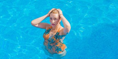 Tropik tatil köyünde güzel bir rahatlama, tatil konsepti, havuzda güneşlenen güzel bir kadın.