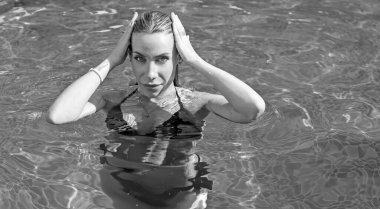 Tropik tatil köyünde güzel bir rahatlama, tatil konsepti, havuzda güneşlenen güzel bir kadın.