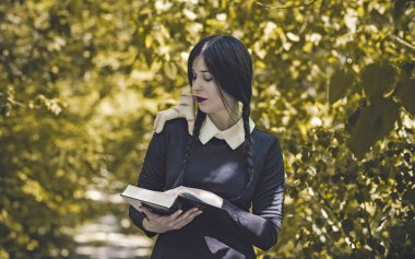 Uzun siyah örgülü gotik kız, Cadılar Bayramı partisi fikirleri, kostümlü ve ürkütücü kostümlü.