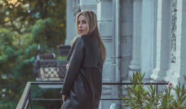 Deri siperli kadın, yeni koleksiyon. Şehir merkezinde zarif sarışın Avrupalı bayan