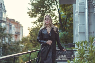 Deri siperli kadın, yeni koleksiyon. Şehir merkezinde zarif sarışın Avrupalı bayan