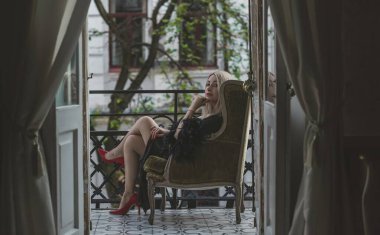 Lüks siyah ipek cüppeli, tüylü zarif sarışın kadın. Kadın kıyafetleri, her gardıropta kusursuzluk.