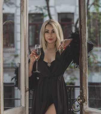 Lüks siyah ipek cüppeli, tüylü zarif sarışın kadın. Kadın kıyafetleri, her gardıropta kusursuzluk.