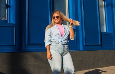 Gülümseyen Avrupalı bir model, günlük giysiler içinde, şehir arkasında. Oldukça hoş, tombul bir kadın.