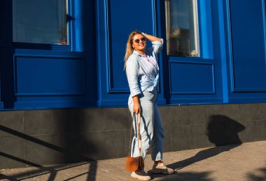 Gülümseyen Avrupalı bir model, günlük giysiler içinde, şehir arkasında. Oldukça hoş, tombul bir kadın.