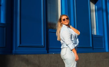 Gülümseyen Avrupalı bir model, günlük giysiler içinde, şehir arkasında. Oldukça hoş, tombul bir kadın.