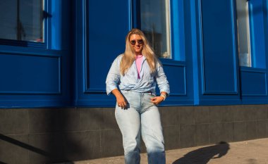 Gülümseyen Avrupalı bir model, günlük giysiler içinde, şehir arkasında. Oldukça hoş, tombul bir kadın.