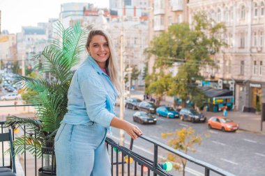 Gülümseyen Avrupalı bir model, günlük giysiler içinde, şehir arkasında. Oldukça hoş, tombul bir kadın.