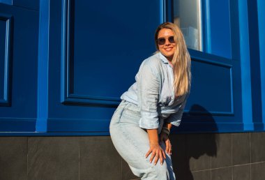 Gülümseyen Avrupalı bir model, günlük giysiler içinde, şehir arkasında. Oldukça hoş, tombul bir kadın.