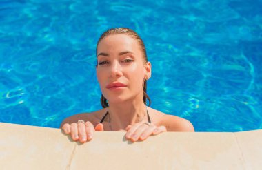 Havuzdaki kadın. Eğlence ve rahatlama kavramı. Hafta sonu güneşlenen güzel bayan.