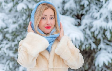 Dışarıda, karlı bir günde, kalın yün elbiseli sarışın bir kadın. Romantik stil