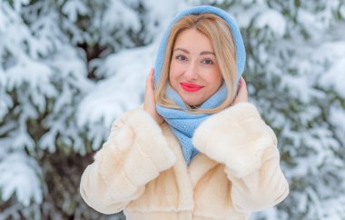 Dışarıda, karlı bir günde, kalın yün elbiseli sarışın bir kadın. Romantik stil