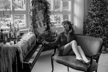 Genç kızıl saçlı bayan Noel atmosferinde evde. Sıcak tatil kavramı