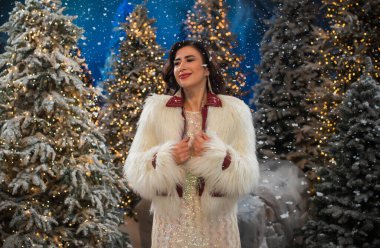 Noel atmosferinde olgun, güzel bir bayan, parti havası. Süslü kıyafetli orta yaşlı kadın. 