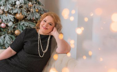 Ayrıca yetişkin bir kadın Noel 'i ya da yeni yılı kutlar. Konforlu evde Avrupalı yaşlı kadın portresi