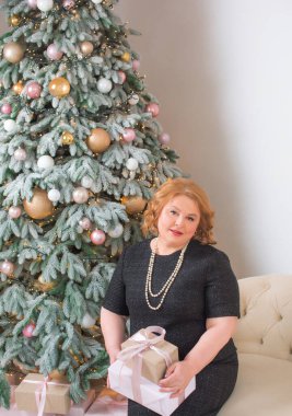 Ayrıca yetişkin bir kadın Noel 'i ya da yeni yılı kutlar. Konforlu evde Avrupalı yaşlı kadın portresi