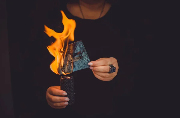 Old life is burning. Concept of depression, divorce. Woman is burn old photos at depression