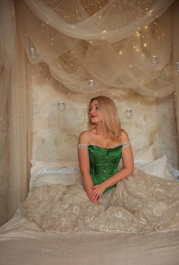 Ortaçağ romantik tarzı. Akşam bej elbiseli ve yeşil ipek korseli kadın.