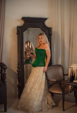 Ortaçağ romantik tarzı. Akşam bej elbiseli ve yeşil ipek korseli kadın.